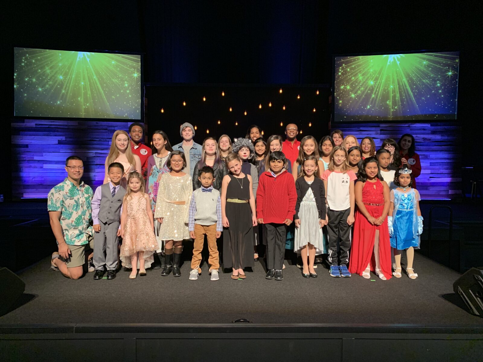 A group of children posing for a photo on stage.