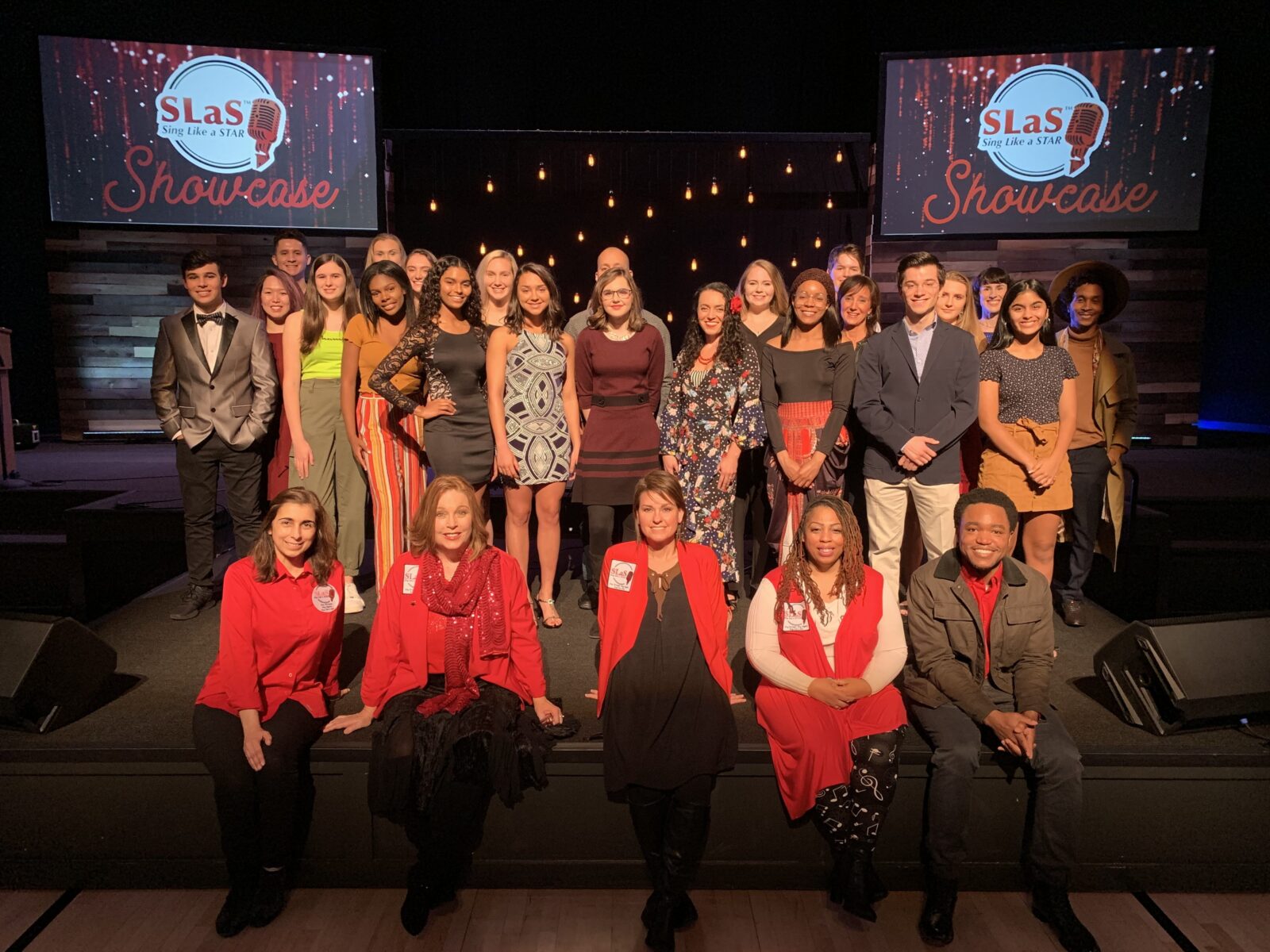 A group of people posing for a photo on stage.