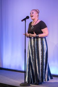 A woman singing into a microphone.