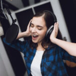 A woman singing a song in a modern recording studio