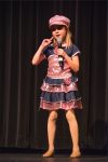 A little girl in a pink dress holding a microphone.